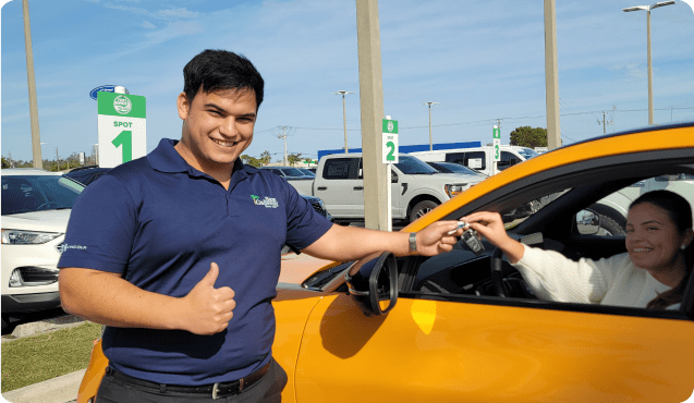 Woman receiving keys to a Test Drive To Go vehicle